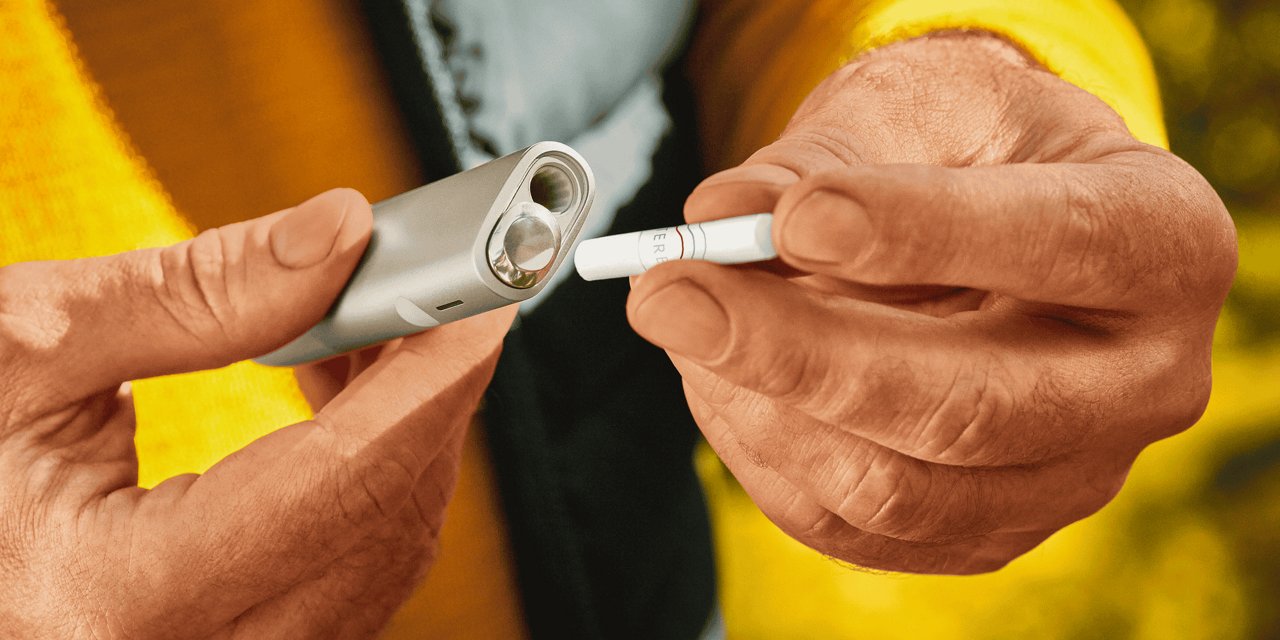 Ein Mann befüllt ein IQOS ILUMA ONE Gerät mit einem TEREA Heetstick.