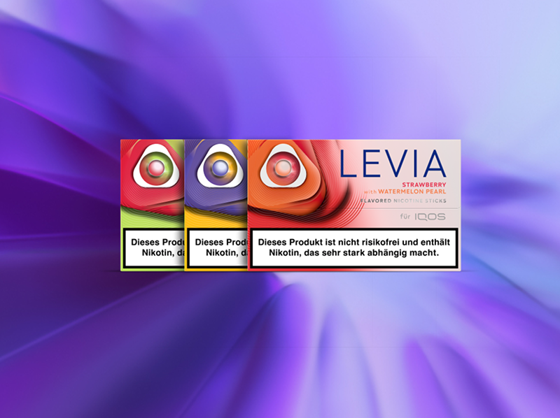 IQOS ILUMA i Gerät neben LEVIA Tabaksticks inverschiedenen Varianten, dargestellt vor einem violetten Farbverlauf