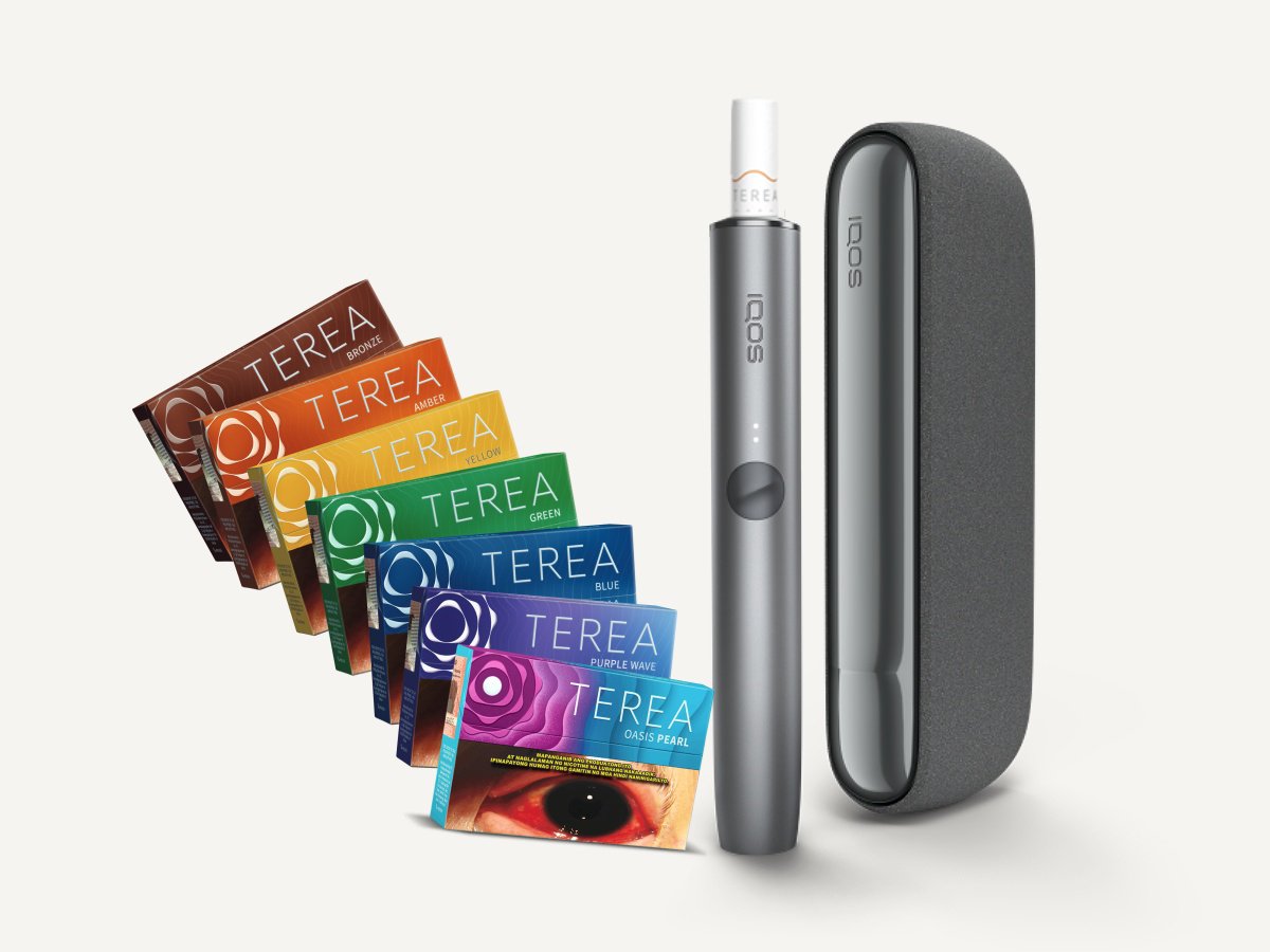 A collection of TEREA heated tobacco packs in various colors arranged in a fan shape, an IQOS holder, and an IQOS charger.