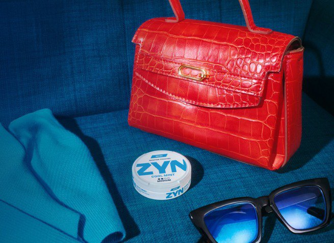 Two women hugging and a third women looking at them and smiling