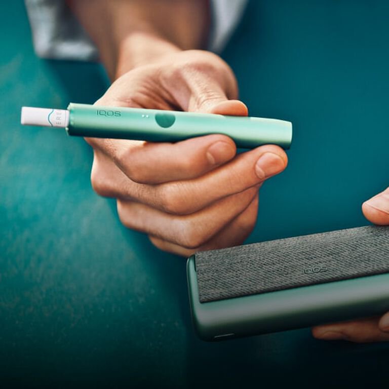 An Obsidian IQOS device and a [colour] IQOS device with sticks inserted