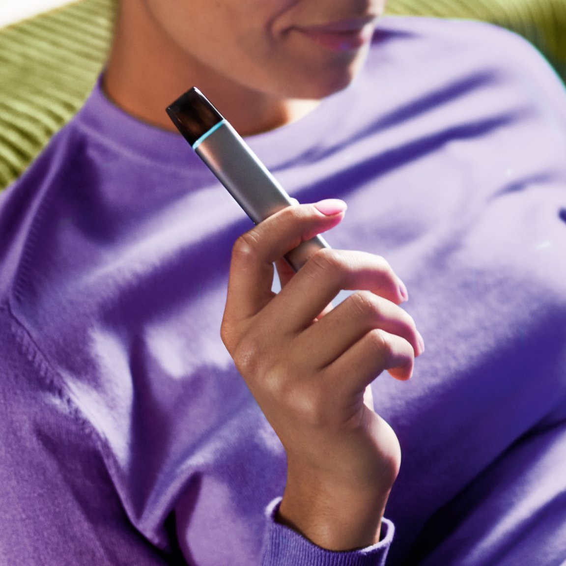 Frau hält eine VEEV ONE und vaped 