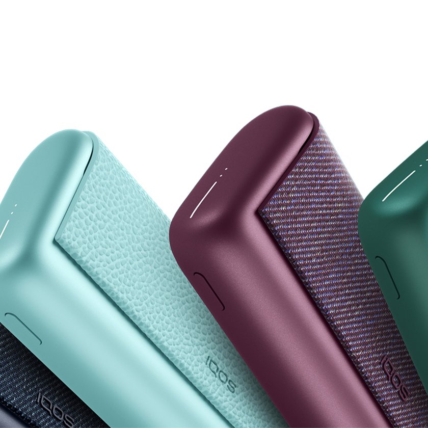 IQOS ILUMA PRIME en colores verde menta y burdeos sobre fondo oscuro, con texto “Guía de uso IQOS ILUMA PRIME”.