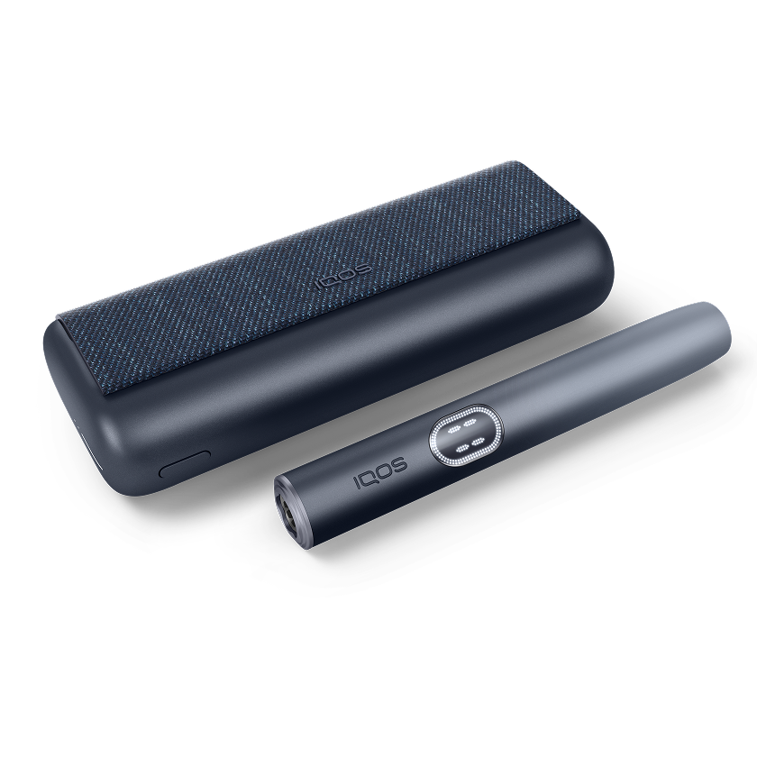 Кара графит түсүндөгү IQOS ILUMA i PRIME кармагычы жана заряддагычы ак фондо көрсөтүлгөн