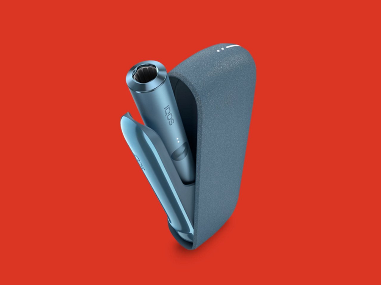 Устройство IQOS ILUMA синего цвета на красном фоне