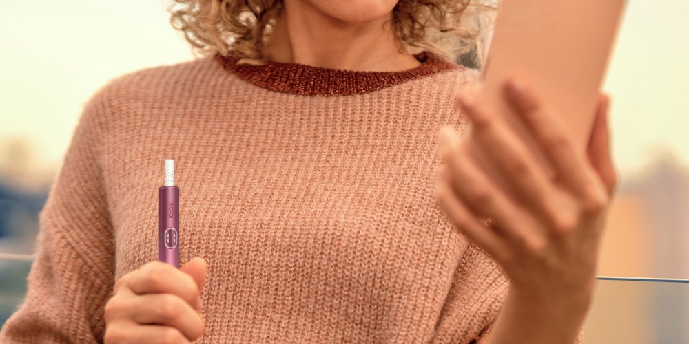 IQOS ILUMA i Tabakerhitzer mit einem User dargestellt.