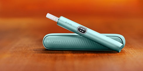 IQOS ILUMA i Tabekerhitzer dargestellt auf einem Holztisch.