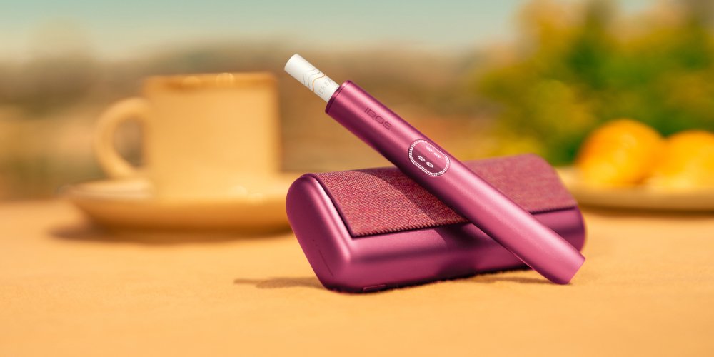 IQOS ILUMA i Tabekerhitzer in der Farbe Garnet Red dargestellt auf einem Holztisch.