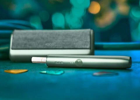 جهاز وشاحن IQOS ILUMA باللون الأخضر.
