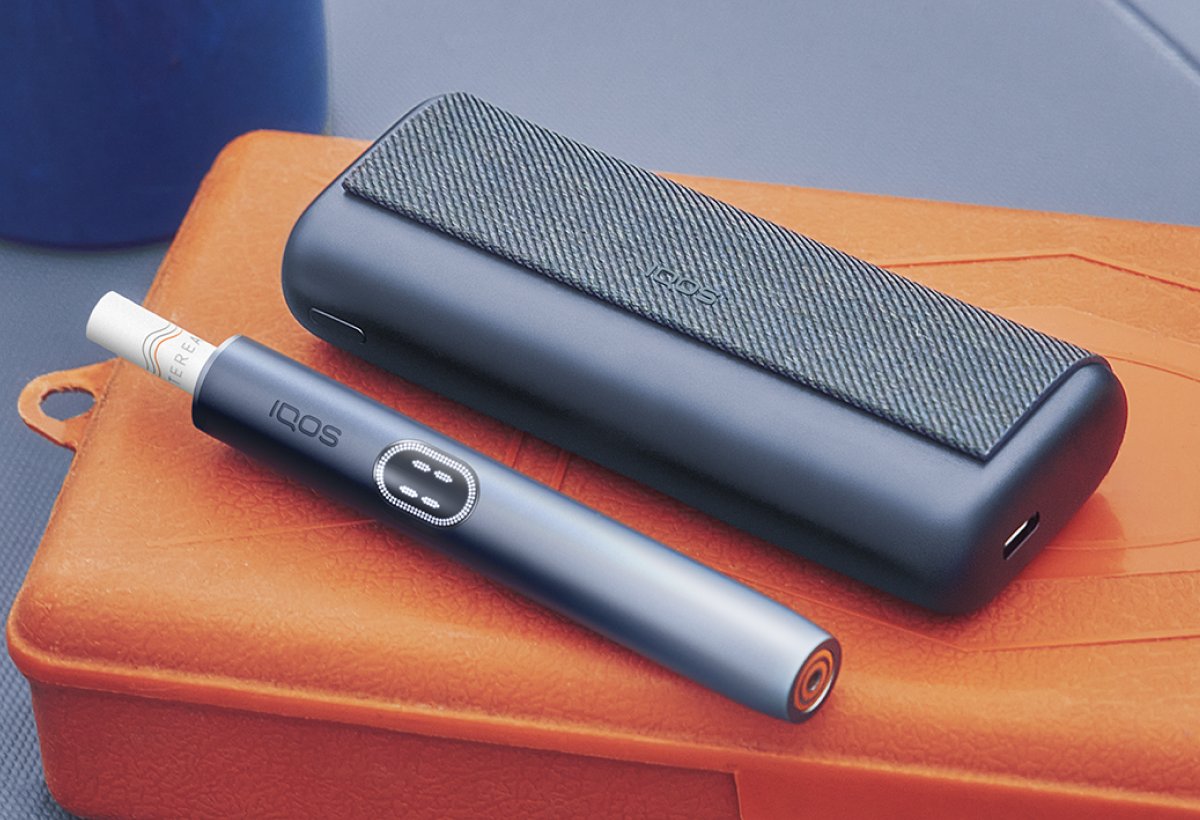 IQOS ILUMA i PRIME auf einem Holztisch.