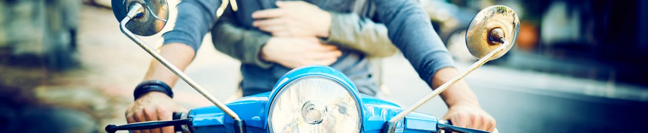 Two people on a scooter - close up detail