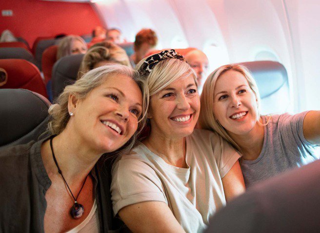 Three women taking a selfie on a plane