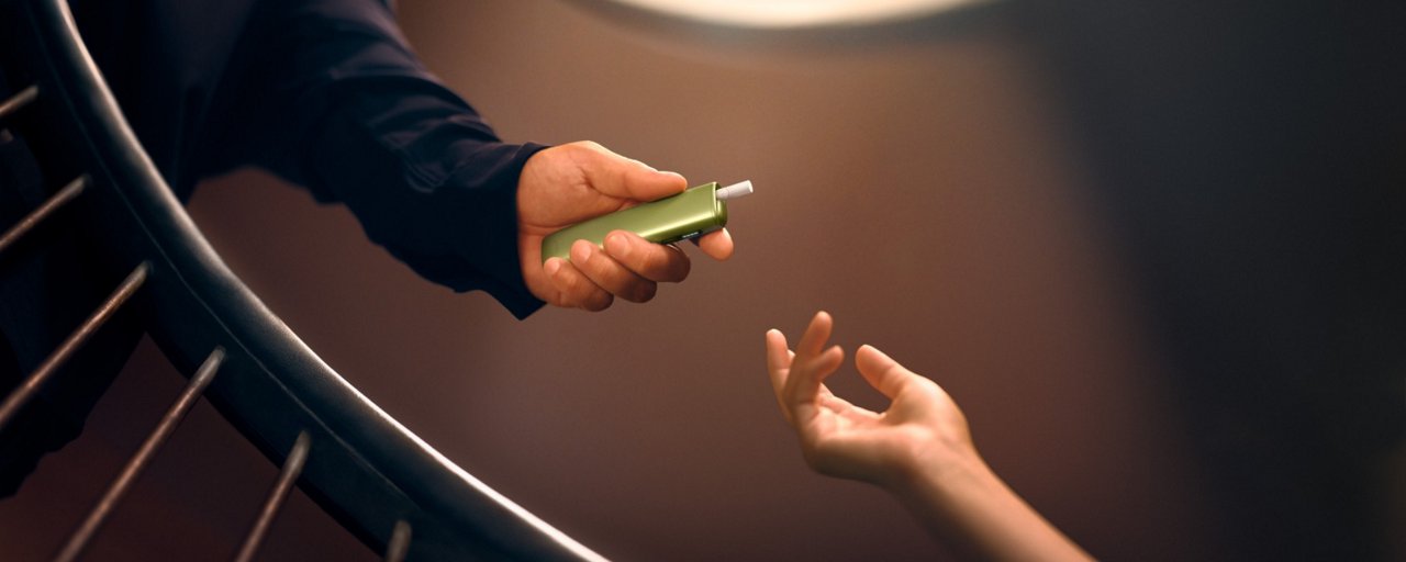 a hand holding IQOS ILUMA i