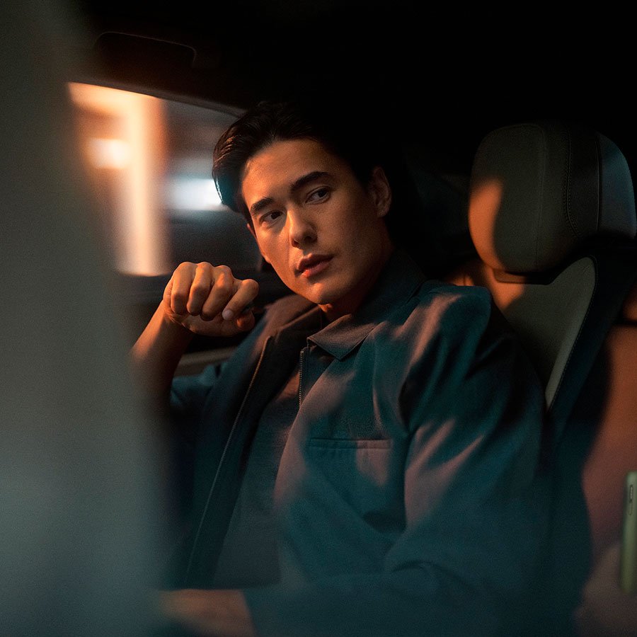 Эркек киши автомобилдин арткы орундугунда отурат