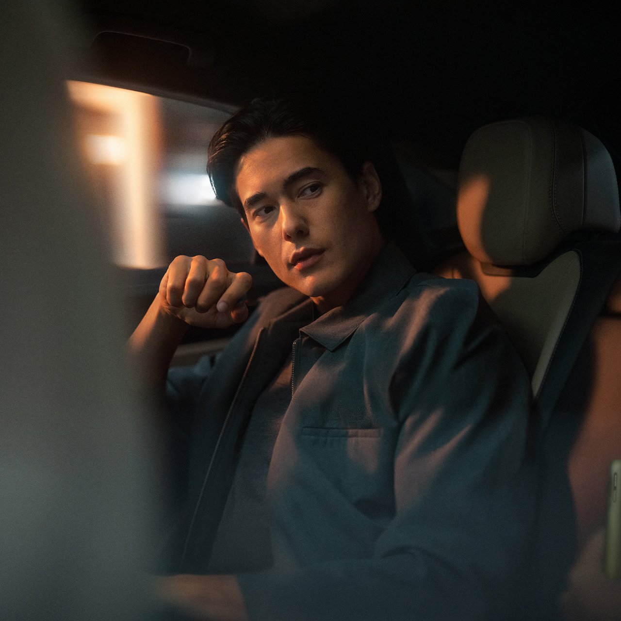 Эркек киши автомобилдин арткы орундугунда отурат