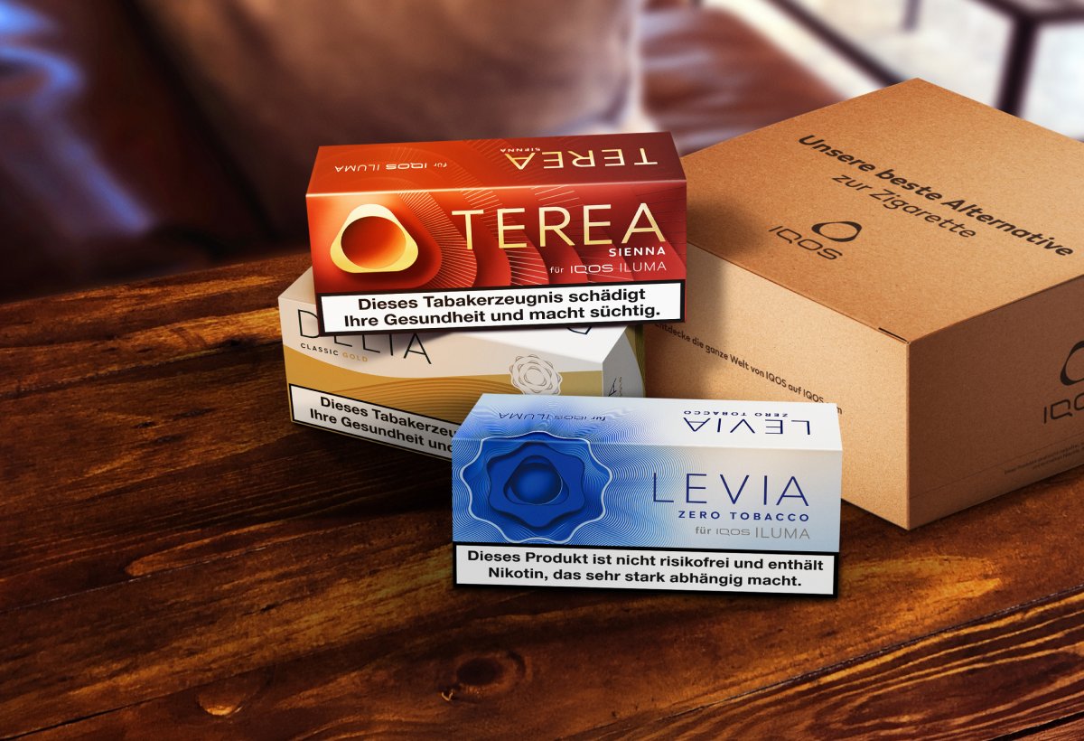 Packungen von TEREA und LEVIA Tabaksticks legen auf einem Tisch neben einer IQOS Verpackung