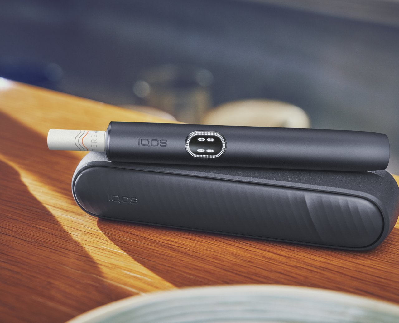 Ein schwarzes IQOS ILUMA i Gerät auf einem Tisch