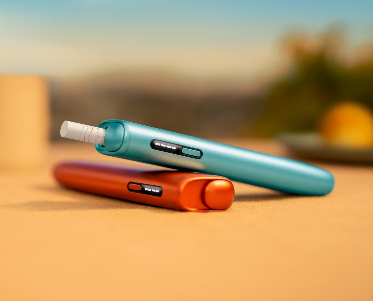 Zwei IQOS ILUMA i ONE Holder auf einem hellen Tisch