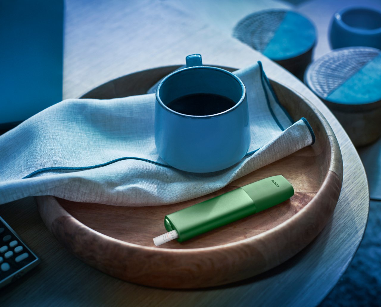 IQOS ILUMA ONE mit TEREA Tabakstick neben einer Tasse auf einem Tablett.