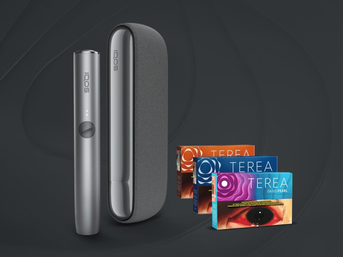 An IQOS device and three packs of TEREA. The IQOS device consists of a sleek, metallic holder and a case with a fabric-like texture. The three packs of TEREA are displayed in the background.