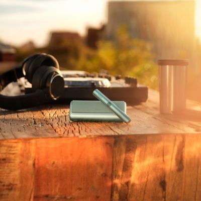 Documentos de viaje, un teléfono móvil, un Holder y un Pocket Charger sobre una mesa.