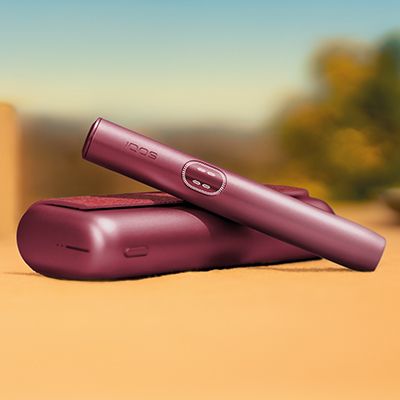 Two IQOS devices with  sticks inserved on a table.