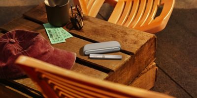 Dos personas sosteniendo unos celulares sobre 2 tazas de café