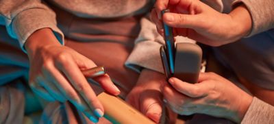 Un par de amigos mostrando sus dispositivos IQOS Iluma.