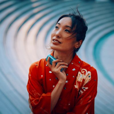 Mujer sosteniendo un IQOS ILUMA i PRIME color Breeze Blue en su mano