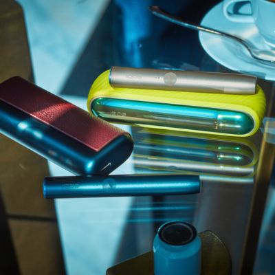 IQOS DUO on a table while two people are talking