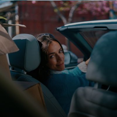 Mujer sentada en un carro con un saco azul