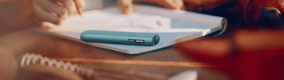 Un IQOS ILUMA i ONE color Breeze Blue sobre una mesa