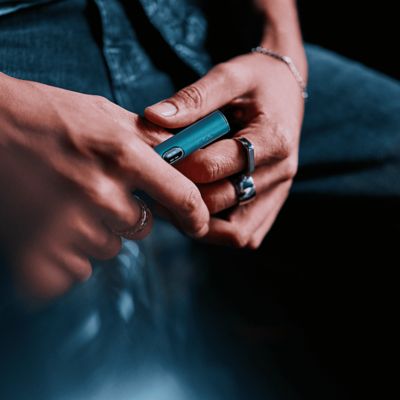 Persona sosteniendo un IQOS ILUMA i PRIME color Midnight Black