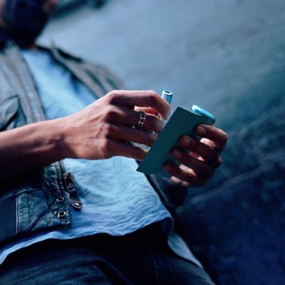 Persona sosteniendo un IQOS ILUMA i PRIME color Breeze Blue