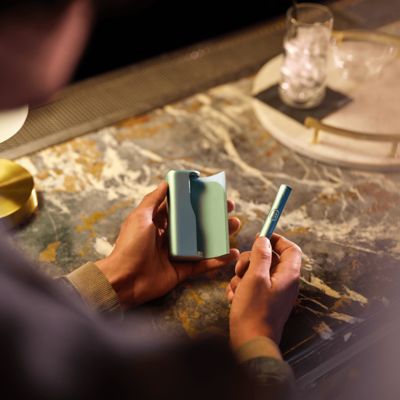 Persona sosteniendo en sus manos un IQOS ILUMA i PRIME en color Breeze Blue