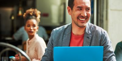 Muž sedící v kavárně s laptopem.