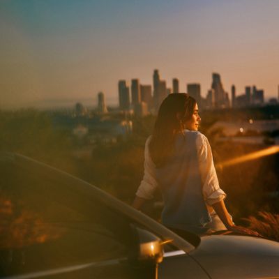 Mujer viendo el atardecer de una ciudad
