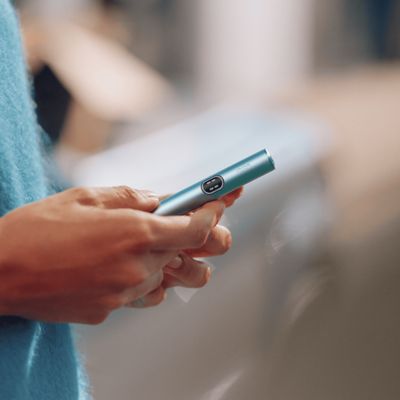 Persona sosteniendo un IQOS ILUMA i color Breeze Blue