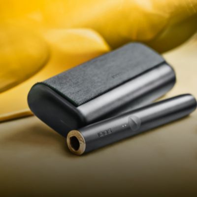 An IQOS ILUMA PRIME Holder in a person's hands, the lights visibile.