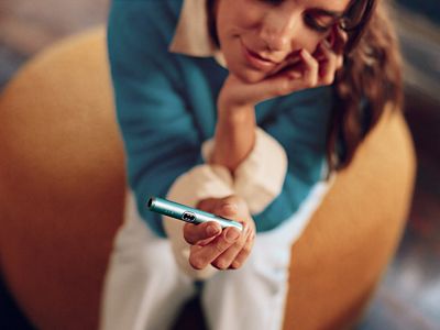 mujer sosteniendo un IQOS ILUMA i PRIME color Breeze Blue