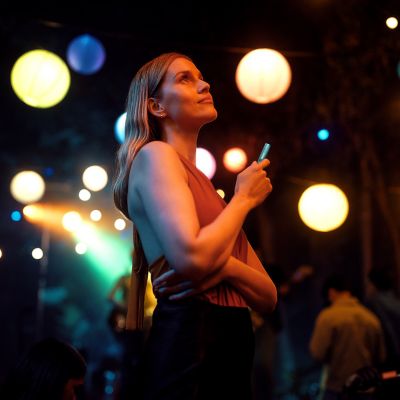 Mujer sonriendo con un IQOS ILUMA