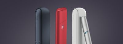 Schwarzer IQOS DUO neben einem roten IQOS ORGINAL ONE neben einem silbernen IQOS ORGINAL Silver Gerät