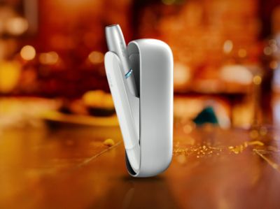 Ein IQOS ORIGINALS Gerät steht auf einem Tisch