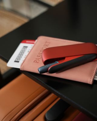 Ein rote IQOS Originals DUO und Reiseunterlagen