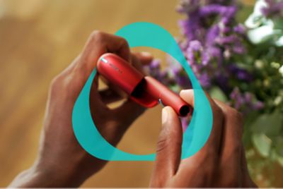 Hände halten ein rotes IQOS ORIGINALS DUO. 