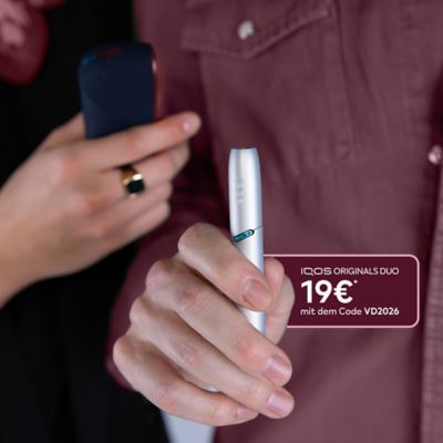 IQOS ORIGINALS DUO Silver wird von einer Hand gehalten die ein rotes Hemd trägt