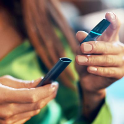 Hände die ein VEEV Pod in ein VEEV Device einführen.