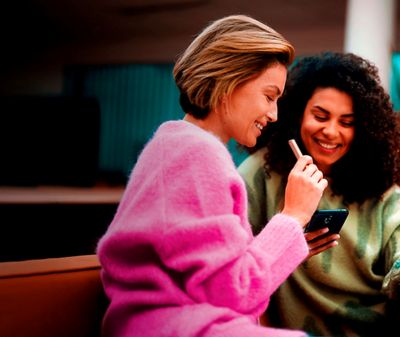 Dvě ženy držící IQOS a mobilní zařízení