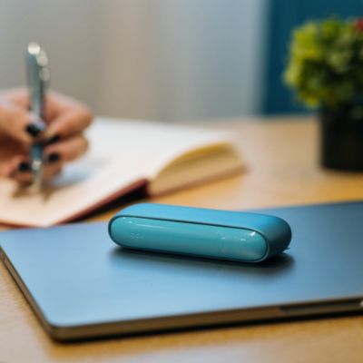 Ein Turquoise IQOS Originals DUO liegt auf einem Laptop