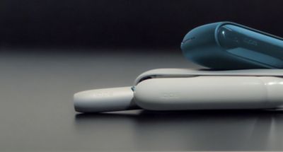 Zwei IQOS ORGINAL DUO Gertäte liegen  seitlich aufeinander